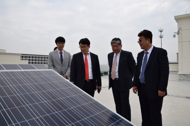 OCI CEO Lee Woo-hyun (second from left) examines the company’s newly-constructed solar plant located on the rooftop of the CMAG company building in Jiaxing, China. (OCI)