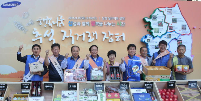 16일 서울 삼성전자 서초사옥 딜라이트 광장에서 열린 ‘추석 직거래장터’에 삼성 사장단들이 참석해 자매마을의 부스에서 일일점장으로 활동하고 농산물도 구입했다. 일일점장으로 나선 이상훈 삼성전자 사장(맨 왼쪽)과 신종균 삼성전자 사장(왼쪽 세번째), 박근희 삼성사회공헌위원회 부회장(왼쪽 네번째), 김창수 삼성생명 사장(왼쪽 여섯번째), 박동건 삼성디스플레이 사장(왼쪽 여덟번째) 등 직거래 장터에 참가한 각 지역 농업인들과 기념촬영을 하고 있다.
