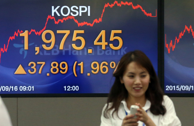 A currency dealer at KEB Hana Bank in Seoul smiles on Wednesday, when the Korean won and equities finished strong (Yonhap).