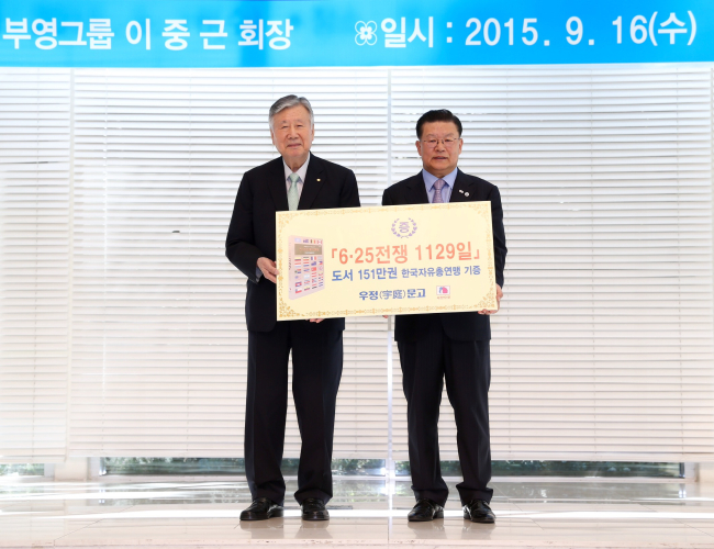 부영그룹 이중근 회장(왼쪽)이 16일 오전 서울 장충동 소재 한국자유총연맹에서 ‘6ㆍ25전쟁 1129일’ 요약본 151만권을 기증하고 허준영 총재와 기념촬영을 하고 있다.
