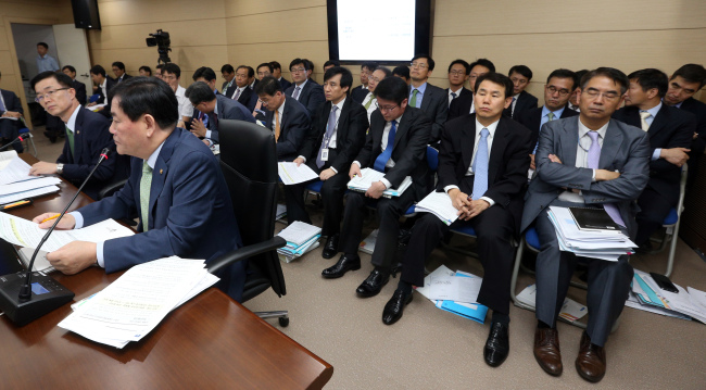<YONHAP PHOTO-2451> 국감장의 기재부 직원들 (세종=연합뉴스) 배재만 기자 = 최경환 부총리 겸 기획재정부 장관이 14일 오전 정부세종청사에서 열린 국회 기획재정위의 기획재정부에 대한 국정감사에서 위원들의 질의에 답하고 있다.뒤로 기재부 실국장 및 관련 공무원들이 자리하고 있다. 2015.9.14 scoop@yna.co.kr http://blog.yonhapnews.co.kr/f6464/2015-09-14 15:34:30/ <저작권자 ⓒ 1980-2015 ㈜연합뉴스. 무단 전재 재배포 금지.>
Officials of the Ministry of Strategy and Finance wait to help Minister Choi Kyung-hwan (front row, second from left) at the parliamentary audit session on Sept. 14.   Yonhap