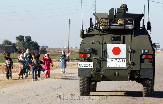 This Jan. 20, 2004 file photo shows Japanese soldiers being cheered by Iraqi children as they leave their base in the southern town of Samawa one day after entering a conflict zone for the first time since World War II. (AP-Yonhap)