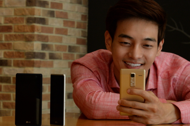 LG’S UNIBODY SMARTPHONE -- A model poses holding a LG Metal Phone in his hand. The tech giant LG Electronics’ latest mid-range smartphone featuring a unibody metal design, a 5-inch display and 8MP front-facing camera is priced at 399,300 won ($340). (LGE)