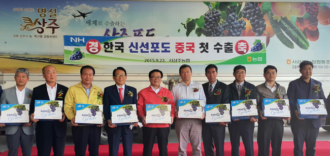 South Korean Agriculture Minister Lee Dong-phil (fifth from left) pose with Nonghyup officials after celebrating Korea's first export of "Haneul Green," a type of locally grown geobong grape, to China in Sangju, North Gyeongsang Province, on Tuesday. (Yonhap)