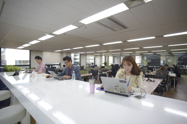 Yuhan-Kimberly employees work in an open-plan office at the firm’s headquarters in Seoul.   Yuhan-Kimberly