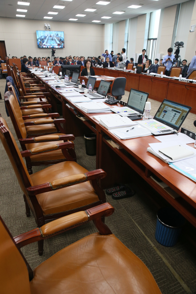 Lawmakers storm out of a meeting room after they clashed over the witness list for parliamentary probe. Yonhap