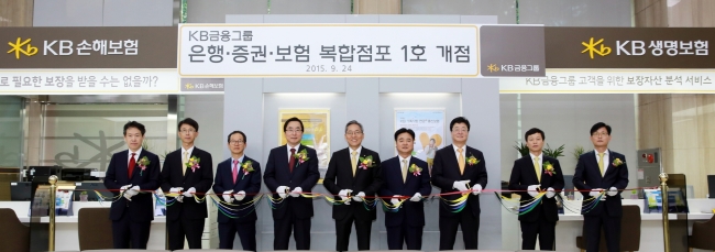 24일 KB국민은행 여의도영업부에서 KB금융그룹 은행ㆍ증권ㆍ손해보험ㆍ생명보험 복합점포 개점행사에 참여한 KB금융그룹 윤종규 회장(사진 왼쪽에서 다섯번째)과 임직원이 테이프 커팅식을 하고 있다.  [사진제공=KB금융그룹]