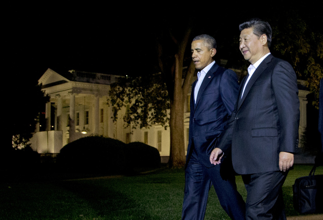 Chinese President Xi Jinping (right) and U.S. President Barack Obama walk at the North Lawn of the White House in Washington on Thursday. (Yonhap/AP)