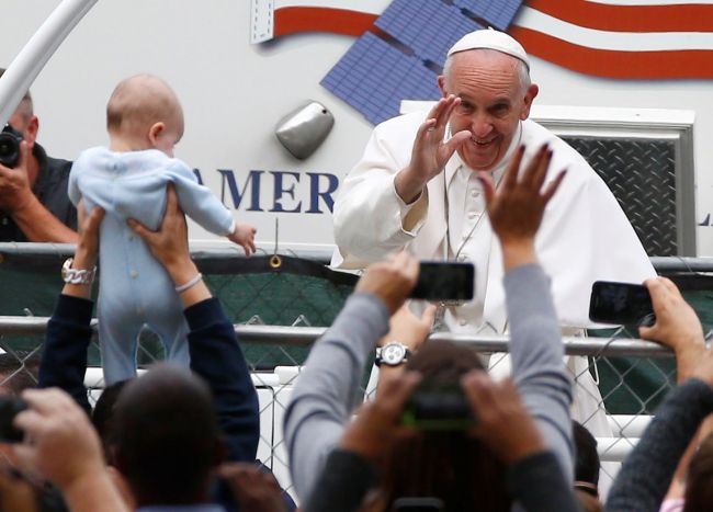 Pope Francis waves to people from the popemobile during a parade on Sunday in Philadelphia. (Yonhap-AFP)