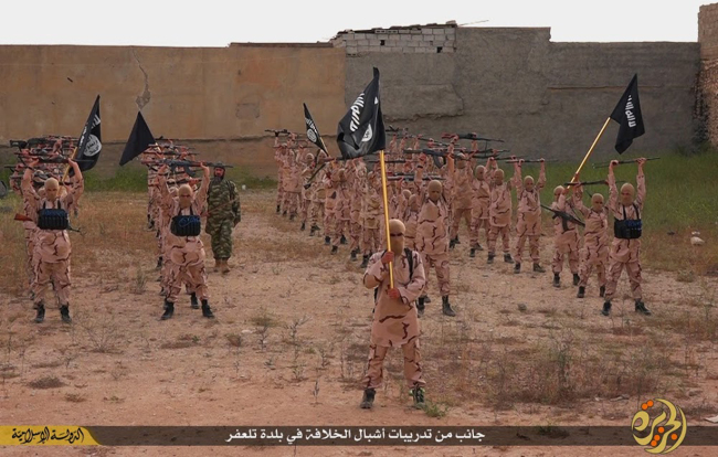 In this photo released on April 25, 2015, by a militant website, young boys known as the "lion cubs" hold rifles and Islamic State group flags as they exercise at a training camp in Tal Afar, near Mosul, northern Iraq (Yonhap-AP)