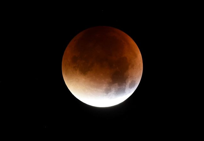 The start of total lunar eclipse to a blood moon is seen in the dark sky in Essen, western Germany, on Monday. (Yonhap-AFP)