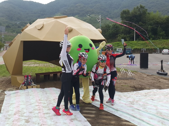 포스코가 전라남도 광양 섬진마을에 조성한 두꺼비 형상의 철 조형물 및 쉼터 ‘새집다오’. 섬진강 인근을 지나던 라이더들이 기념사진을 찍고 있다. 왼쪽은 포스코가 독자 개발한 ‘녹슬지 않는 철’ 포스맥으로 만들어진 ‘팡도라네’.
