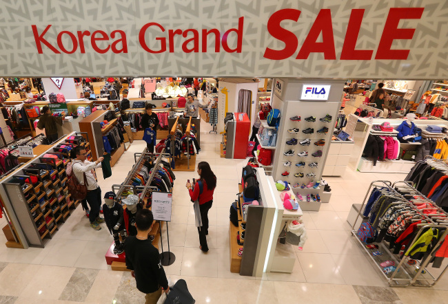 Customers browse products at a clothing store at Lotte Department Store in Myeong-dong in central Seoul during the first day of Korea Black Friday event on Thursday.   Yonhap