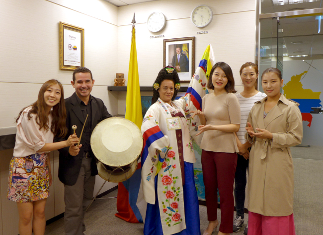 Colombian traditional instrumentalist Jarry Jose Julio Arjona (second from left) and dancer Maribel Egea Garia (center) pose with members of the Colombian Embassy and Korean Classical Music Corporation during an educational exchange at the embassy in Seoul in late September.   Joel Lee/The Korea Herald