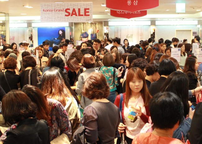 Lotte Department Store in Myeong-dong, central Seoul, is crowded with shoppers during the Korean Black Friday event on Monday.   Lotte Department Store