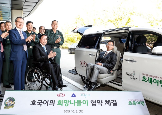 <YONHAP PHOTO-2509> 기아차 "장애가족의 입대장병 면회 지원합니다" (서울=연합뉴스) 기아차는 6일 육군본부에서 '호국이의 희망나들이 사업 협약식'을 가졌다. 호국이의 희망나들이 사업은 기아차와 육군본부가 휠체어를 이용하는 장애가족의 입대장병 면회를 돕기 위해 체결한 공동 협력사업이다. 기아차와 육군본부는 사단법인 그린라이트와 함께 오는 11월부터 매달 5가족을 선정해 지원할 예정이다. 신청은 이달부터 초록여행 홈페이지를 통해 받는다. 대상자는 기아차의 초록여행 차량인 '카니발 이지무브'와 면회여행 경비를 제공받게 된다. 기아차 특수사업본부장 이일섭 상무, (사)그린라이트 김선규 회장, 육군본부 인사참모부장 김해석 소장 등 참석자들이 기아차 카니발 이지무브 앞에서 박수를 치고 있다. 2015.10.6 << 기아차 제공 >> photo@yna.co.kr/2015-10-06 16:05:02/ <저작권자 ⓒ 1980-2015 ㈜연합뉴스. 무단 전재 재배포 금지.>