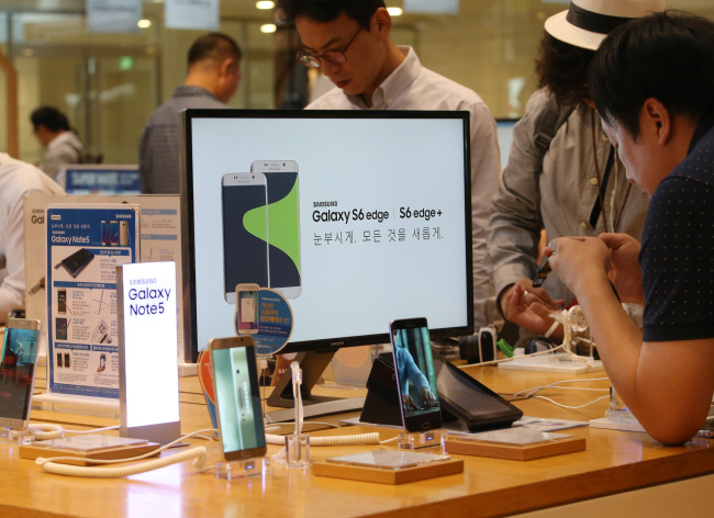 Customers try out Samsung devices at a store near the company's headquarters in Seocho-dong, southern Seoul, on Wednesday. Yonhap