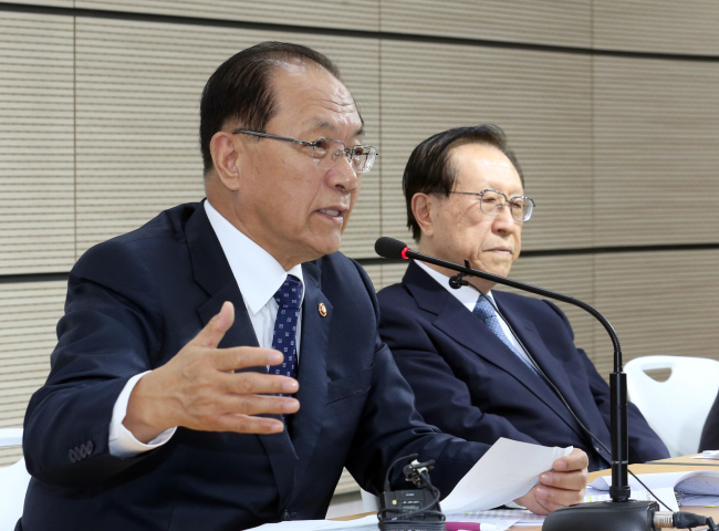 Education Minister Hwang Woo-yea (left) answers questions during a policy briefing on Monday about the government plans to revive state history textbooks for secondary education at Sejong Government Comlex. (Yonhap)