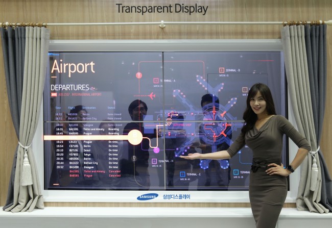 SAMSUNG SHOWCASES FUTURE DISPLAY -- A model poses with a transparent OLED display produced by Samsung Display at the International Meeting on Information Display 2015, an annual conference for the display industry held from Wednesday to Friday at KINTEX in Ilsan. (Samsung Display)