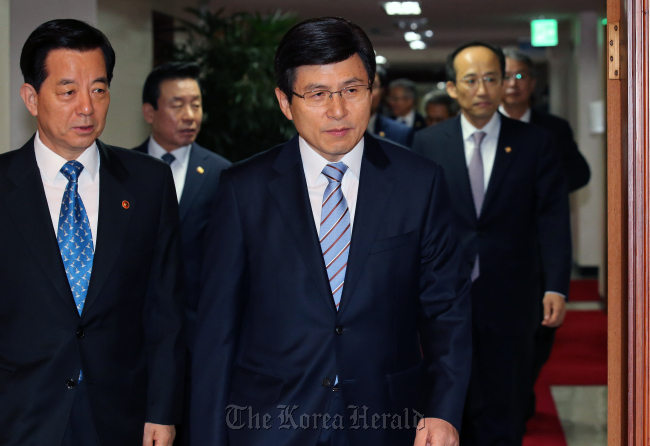 Prime Minister Hwang Kyo-ahn (right, front), Defense Minister Han Min-koo (left, front) and other officials head to a video conferencing room at the government complex in Seoul on Tuesday for the weekly cabinet meeting. (Yonhap)