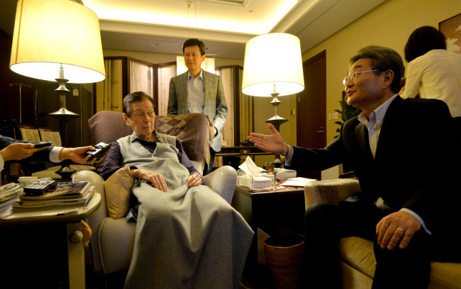 Lotte Group founder and general chairman Shin Kyuk-ho (left) and his eldest son Shin Dong-joo (second from left) speak with reporters inside the general chairman’s office in Lotte Hotel Seoul on Friday. (Yonhap)