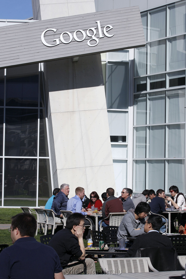 Google Inc. employees sit outside at the company’s headquarters in Mountain View, California. (Bloomberg-Yonhap)