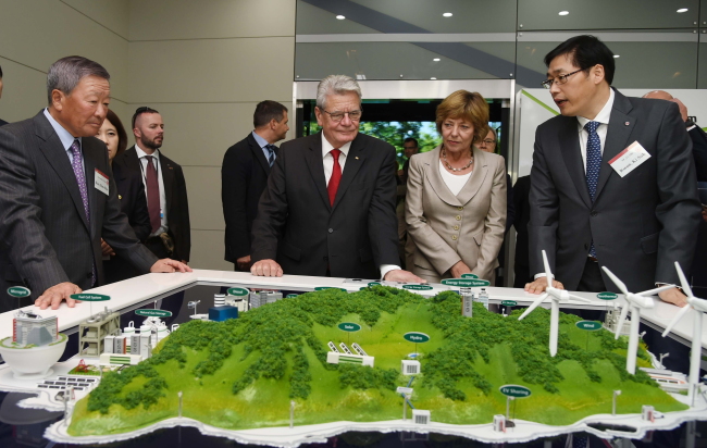 German President Joachim Gauck and his wife Daniela Schadt (center) and LG Group chairman Koo Bon-moo (left) look around an exhibition hall at LG Display’s Paju plant in Gyeonggi Province on Oct. 14. 	LG Group