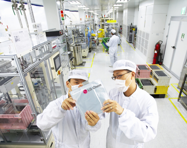LG Chem researchers inspect an automotive battery cell at the company’s Ochang plant in North Chungcheong Province. LG Chem