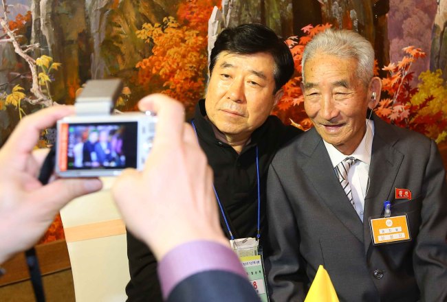 <YONHAP PHOTO-2332> <이산상봉> 삼촌과 함께 기념촬영 (금강산=연합뉴스) 김도훈 기자 = 제20차 이산가족 상봉행사 1회차 둘째날인 21일 오전 금강산호텔에서 열린 공동중식에서 염순택(63)씨가 북측에서 온 삼촌 염진봉(84) 할아버지와 기념촬영을 고 있다. 2015.10.21 superdoo82@yna.co.kr/2015-10-21 14:03:32/ <저작권자 ⓒ 1980-2015 ㈜연합뉴스. 무단 전재 재배포 금지.>
Yeom Soon-taek (left), 63, poses for a photograph with his long-lost uncle Yeom Jin-bong, 84, in North Korea during the second day of reunions of separated families at Geumgangsan Hotel on Wednesday.   Yonhap