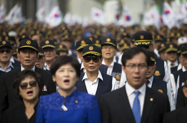 <YONHAP PHOTO-2247> 애국가 부르는 참석자들 (서울=연합뉴스) 윤동진 기자 = 22일 오후 용산구 서울역 광장에서 열린 '좌편향 교과서 바로잡기 국민대회'에서 참석자들이 애국가를 부르고 있다. 2015.10.22 mon@yna.co.kr/2015-10-22 15:21:07/ <저작권자 ⓒ 1980-2015 ㈜연합뉴스. 무단 전재 재배포 금지.>
Participants of a rally decrying the “political bias” of current history textbooks including ruling Saenuri Party officials sing the national anthem Thursday at Seoul Station in Yongsan-gu, Seoul.   Yonhap