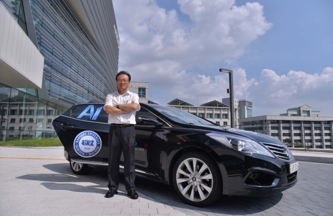 Sunwoo Myoung-ho, professor of automotive engineering at Hanyang University, poses next to a fourth generation self-driving car developed by the Automotive Control and Electronics Laboratory at the university’s Seoul campus on Sept. 3.  (Lee Sang-sub/The Korea Herald)