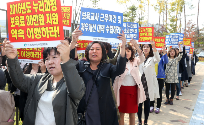 Teachers at child care centers protested on Friday over the government's decision to cut its budget for child care programs. Yonhap.