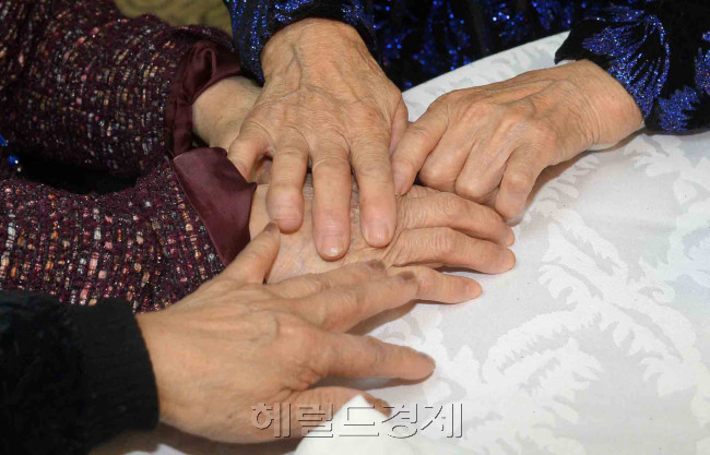 2014년 2월. 이산가족 상봉 행사장에서 헤어졌던 가족들의 맞잡은 손에서 만남의 기쁨과 그리움. 그 온기를 조금이라도 더 기억하고자 하는 절절함이 느껴진다. [사진=헤럴드경제 DB]