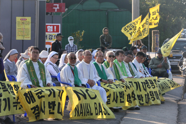 <YONHAP PHOTO-2182> 제주 평화의 섬 실현을 위한 천주교연대 출범 4주년 미사 (서귀포=연합뉴스) 박지호 기자 = 12일 제주 서귀포시 강정동 제주해군기지 공사장 앞에서 '제주 평화의 섬 실현을 위한 천주교연대' 출범 4주년 생명평화미사가 열리고 있다. 2015.10.12 jihopark@yna.co.kr/2015-10-12 17:24:58/ <저작권자 ⓒ 1980-2015 ㈜연합뉴스. 무단 전재 재배포 금지.>
Priests hold Mass in front of the construction site on Jejudo Island on Oct. 12 in protest against the anticipated launch of a naval base. Yonhap