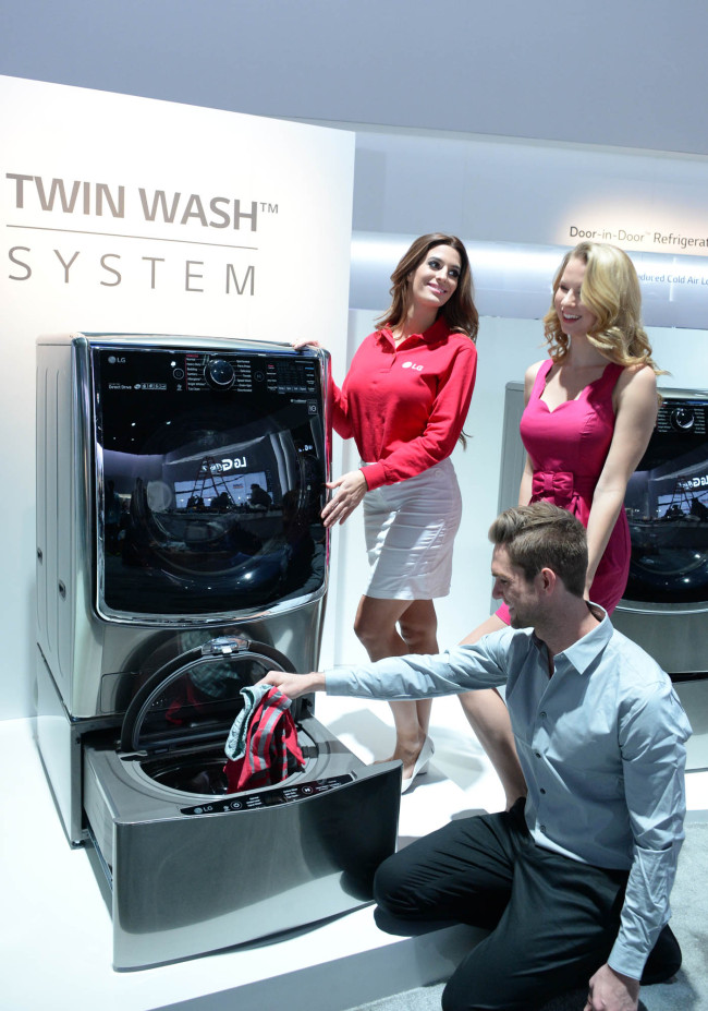 Models pose with LG Electronics‘ Twin Wash, featuring two washing tubs -- one on the top and another on the bottom -- at the CES electronics trade show in Las Vegas in January. (LGE)