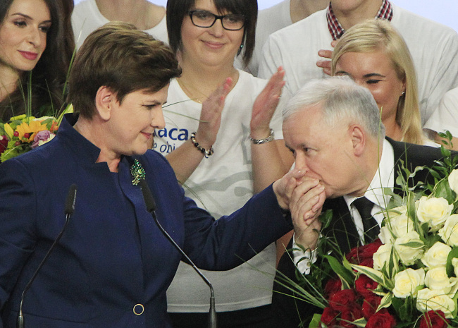 Conservative Law and Justice leader Jaroslaw Kaczynski kisses the hand of Justice candidate for the Prime Minister Beata Szydlo (left) at the party's headquarters in Warsaw, Poland, Sunday. (AP-Yonhap)