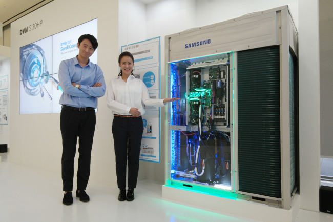 Models pose with Samsung Electronics’ 360 Cassette air-conditioning system, an omnidirectional air conditioner for large buildings. (Samsung)