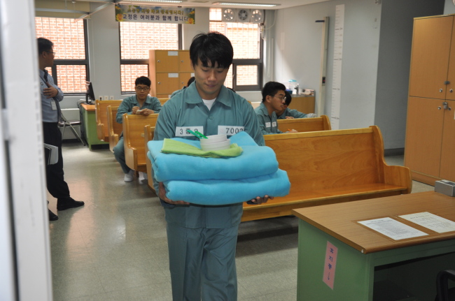 26일 법무부에서 주재한 ‘수용자 체험’에 참여한 본지 김진원 기자가 서울 남부교도소에서 모포와 식기를 받아 이동하고 있다.