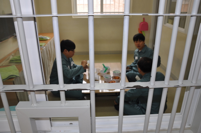 26일 법무부에서 주재한 ‘수용자 체험’에 참여한 기자들이 창살 너머에서 점심 식사를 하고 있다.