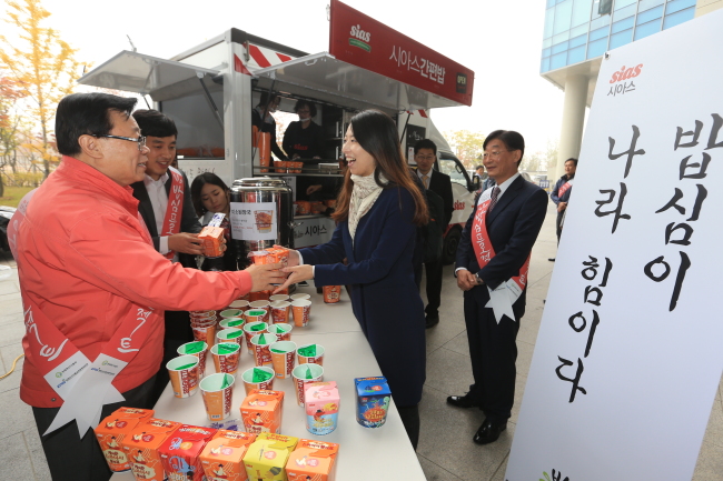 이동필(왼쪽) 농림축산식품부 장관이 지난 23일 정부세종청사 앞에서 출근하는 직원들에게 간편식 아침밥을 나눠주며 건강과 우리쌀 소비를 당부하고 있다. [사진제공=농림축산식품부]