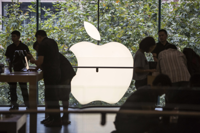 Customers look at products during the sales launch of the iPhone 6s and iPhone 6s Plus at the IAPM shopping mall in Shanghai, China.   Bloomberg