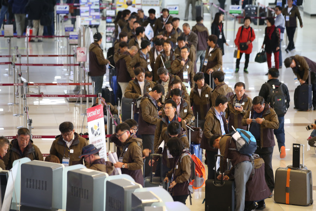 South Korea's labor union members wait in line at an airport to attend freindly soccer match in Pyongyang. Yonhap
