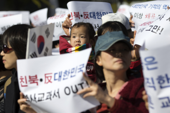 <YONHAP PHOTO-2567> '친북·반대한민국 역사교과서 OUT' (서울=연합뉴스) 윤동진 기자 = 29일 서울 광화문광장 이순신 동상 앞에서 열린 친북·반대한민국 역사교과서 정상화 청년대학생 선언에서 참석자들이 좌편향 역사교과서 제작 중단을 촉구하는 내용이 적힌 종이를 들고 있다. 2015.10.29 mon@yna.co.kr/2015-10-29 13:43:43/ <저작권자 ⓒ 1980-2015 ㈜연합뉴스. 무단 전재 재배포 금지.>
Activists in support of the government’s plan for state-authored textbooks stage a protest against the current history textbooks in Gwanghwamun, central Seoul, Thursday.   Yonhap