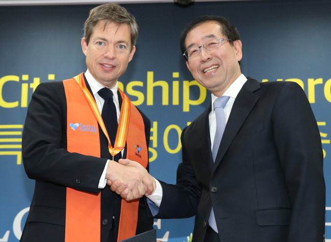 "The homeless billionaire" Nicolas Berggruen (left) shakes hands with Seoul Mayor Park Won-soon. Yonhap