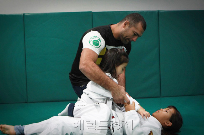 “깃을 확 낚아채.” 쇼군 후아가 마운트포지션 탑을 차지한 여자 아이에게 기술을 조언하고 있다. [사진제공=무진(www.moozine.net)]