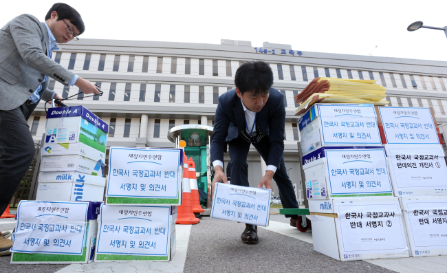 <YONHAP PHOTO-1346> 역사교과서 국정화 반대 의견서 및 서명서 옮기는 교육부 직원들 (세종=연합뉴스) 배재만 기자 = 교육부 직원들이 2일 오후 정부세종청사 교육부 앞에서 새정치민주연합이 제출한 역사교과서 국정화에 반대하는 의견서와 서명지를 사무실로 옮기고 있다. 2015.11.2 scoop@yna.co.kr http://blog.yonhapnews.co.kr/f6464/2015-11-02 15:09:18/ <저작권자 ⓒ 1980-2015 ㈜연합뉴스. 무단 전재 재배포 금지.>
Education Ministry officials move boxes containing petitions gathered and sent by the main opposition New Politics Alliance for Democracy opposing the government’s reinstatement of state-authored history textbooks in front of the ministry building in Sejong City on Monday.   Yonhap