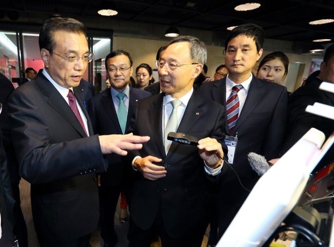 LI VISITS CREATIVE CENTER -- KT chief executive Hwang Chang-gyu (center) introduces an iris recognition solution to Chinese Premier Li Kequiang at a creative economy center run by the Korean mobile carrier in Gyeonggi Province on Monday. The Korean government and Korean conglomerates established 17 creative economy centers across the nation to support start-ups. (KT)
