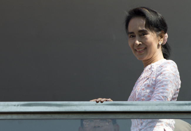 Leader of Myanmar's National League for Democracy party, Aung San Suu Kyi, smiles to her supporters after delivering a speech from a balcony of her party headquarters in Yangon, Myanmar, Monday. (AP-Yonhap)