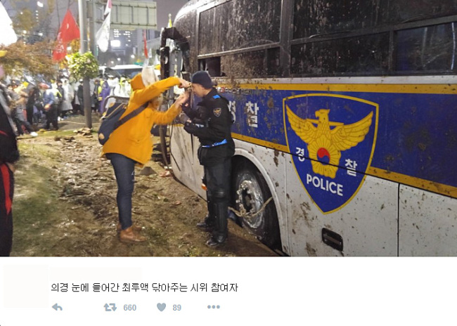 시위중 최루액 맞은 의경 눈 씻어주는 시민 사진 화제 (서울=연합뉴스) 14일 극렬하게 대치했던 시위 현장에서 의경 눈에 들어간 최루액을 씻겨주는 시민의 모습이 담긴 사진이 인터넷 공간에서 화제를 모으고 있다. 15일 오후 현재 해당 사진은 트위터에서 리트윗됐고 페이스북 등 사회관계망서비스(SNS)와 주요 온라인 커뮤니티에서 공유되고 있다. 2015.11.15 << 트위터 캡처 >> photo@yna.co.kr (끝)
A citizen washes tear gas from the face of a conscripted policeman during a mass rally in Gwanghwamun, Seoul, Saturday. The picture posted on Twitter has been shared among numerous social media and online communities.   Twitter