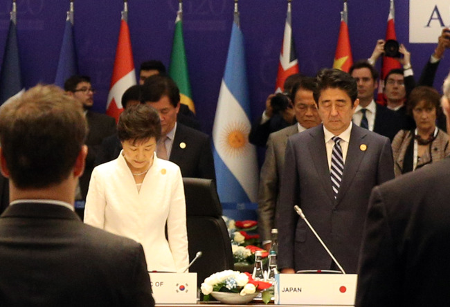 President Park Geun-hye (left) and Japanese Prime Minister Shinzo Abe mourn before the first session of the G20 Turkey Leaders Summit held at a convention center on Monday. Yonhap News
